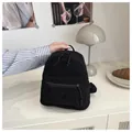 Close-up of black corduroy mini backpack with zipper pocket on a white surface - Black