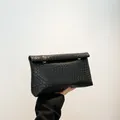Women's black woven crossbody bag in trendy pillow style with minimalist flap and metal closure - Black
