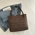 Retro houndstooth tote bag in brown and red stripes displayed on a white textured bed - Brown
