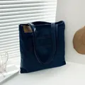 Dunkelblaue Denim-Tragetasche mit braunem Lederpatch und Kontrastnähten - Stil 1