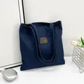 Große marineblaue Denim-Tragetasche mit braunem Lederpatch und langen Schultergurten - Stil 2