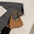 Brown woven texture baguette bag with golden chain strap for women on a stylish suit - Brown