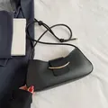 Borsa a spalla nera a mezzaluna con dettagli in metallo dorato e tracolla annodata - Nero