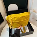 Bright yellow nylon crossbody bag with wide shoulder strap and woven zipper pull detail - Yellow