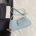 Borsa a spalla a mezzaluna celeste minimalista con chiusura dorata e tracolla con nodi - Blu