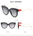 Detailansicht der Cat-Eye-Sonnenbrille mit roten Akzenten und goldenen Bügeln - Schwarz Roter Rahmen Verlauf Graues Glas