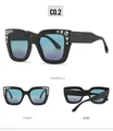 Detailweergave van de zwarte vierkante cat-eye zonnebril met chique strass-accenten - Zwart Frame Blauw Grijze Glazen