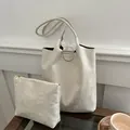 Borsa tote in pelle scamosciata bianco sporco e pochette abbinata su tavolo in legno - Bianco