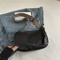 Chic black pillow bag with artistic woven strap and fashion logo in textured vegan leather - Black