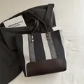 Bolso tote de lona a rayas con correas de cuero marrón oscuro y diseño espacioso - Negro
