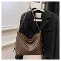 Detail view of the vintage brown geometric pattern and premium leather strap on a hobo bag - Brown