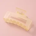 Gros plan d'une pince à cheveux rectangulaire jaune mat sur fond rose doux - Carré Jaune