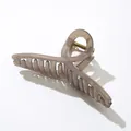 Makro-Detail einer großen bernsteinfarbenen Haarklammer mit goldener Metallfeder - Hellkaffee (13cm)