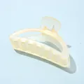 Détail macro d'une grande pince à cheveux mate jaune crème avec des dents solides imbriquées - Demi-circulaire Jaune