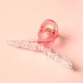 Detail van de 11cm haarklem met roze kleurverloop, gouden veer en transparante hars - Dieproze Gradiënt