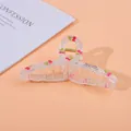 Detail of a large clear resin hair claw clip with cherry patterns and gold spring - Cherry / Large