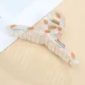 Detail of transparent strawberry hair claw with Barrette La France text and metal spring - Carrot / Standard