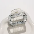 Detail of square hair claw clip featuring elegant black and white marble resin texture - Black