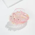 Dettaglio molletta per capelli rosa con fiori, strass lucidi e trama marmorizzata - Lettera A