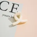 Détail d'une pince à cheveux minimaliste blanc crème avec un design lisse en cœur - Blanc Cassé