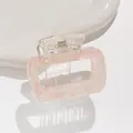 Detail of pink marble hair claw clip with golden spring on a white ceramic tray - Pink
