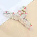 Detailed view of transparent acrylic hair claw with cherry print and golden spring - Cherry / Standard