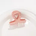 Dettaglio di un mini fermaglio per capelli rosa glitterato con design a nodo incrociato - Rosa