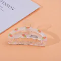 Detail of transparent strawberry hair claw clip with printed Barrette La France text - Semi-circle Carrot / Medium