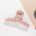 Detail of peach pink glitter hair claw clip with crossed design and shimmer finish - Pink