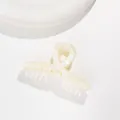 Detail view of cream resin hair claw clip with pearlescent finish and silver spring - Off White