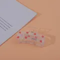 Detail of strawberry print iridescent acrylic hair claw clip with gold metal spring - Square Strawberry