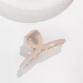 Macro detail of glossy khaki hair claw clip with subtle glitter finish and cross design - Khaki