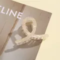 Détail d'une pince à cheveux en acrylique champagne translucide avec ressort doré - Light jaune