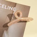 Détail d'une grande pince à cheveux rose champagne avec finition nacrée et torsadée - Khaki Foncé