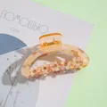 Detailed close-up of amber flower hair claw clip with rhinestones and acrylic petals - Amber Orange