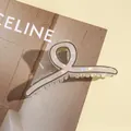 Makroaufnahme einer schillernden Haarklammer aus Acetat mit schickem Drehdesign - Dunkelkaffee
