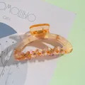 Détails d'une pince à cheveux ambre avec des papillons ornés de strass brillants - Ambre Translucide (D)