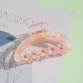 Detail of pink floral hair claw clip with rhinestones on a decorative background - Pink