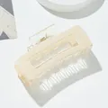 Dettaglio della pinza per capelli quadrata beige con motivo a scacchi e molla dorata - Bianco avorio