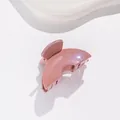 Détail d'une pince à cheveux rose pailletée avec finition en résine et design festonné - Rose