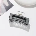 Vue détaillée d'une grande pince à cheveux rectangulaire noire et blanche en acétate - Gris foncé