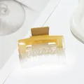 Macro-opname van de amberkleurige haarklem van acryl met een glanzende afwerking - Geel