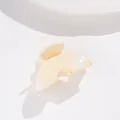 Détail d'une pince à cheveux jaune crème pailletée avec un design en demi-cercle nacré - Blanc Cassé