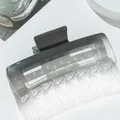 Macro detail of a large square gradient shark hair claw clip in black and clear - Gray