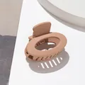 Dettaglio molletta per capelli ovale beige opaco su blocco con illuminazione naturale - Khaki scuro