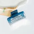 Macro view of a square acrylic hair claw clip with blue transparent gradient finish - Blue