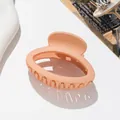 Macro detail of apricot pink matte oval hair claw clip with strong metal spring - Dark Khaki