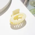 Vista dettagliata della piccola pinza per capelli ovale giallo crema opaco con molla metallica - Bianco avorio