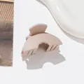 Macro view of matte beige hair claw clip with elegant arched design on a ceramic tray - Light Khaki