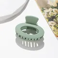 Dettaglio macro di un fermaglio per capelli ovale verde salvia opaco con denti - Verde